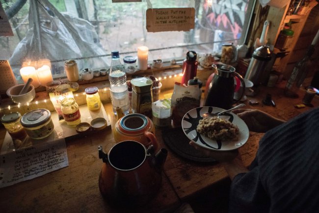 Neben Kerzen und Lichterketten wird Frühstück in einem Baumhaus der Siedlung "Oaktown" zubereitet. Foto: Jana Bauch/dpa