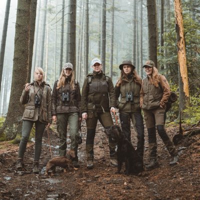 Gruppenbild mit Jägerin Fee Brauwers andere Jägerinnen im Wald zwei Hunde