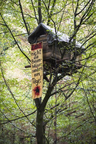 Aus den Baumhäusern der Aktivistien hängen oftmals selbst gemacht Banner. Auf diesem heißt es: „Zählt nicht die Baumhäuser, sondern eure Tage!“ Foto: Jana Bauch/dpa