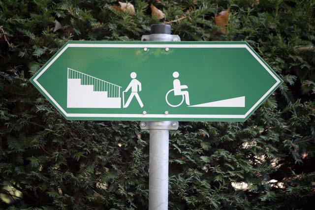 Ein Schild weist darauf hin, dass Fußgänger links eine Treppe und Rollstuhlfahrer rechts eine Auffahrt benutzen können. Quelle: Fredrik von Erichsen,dpa